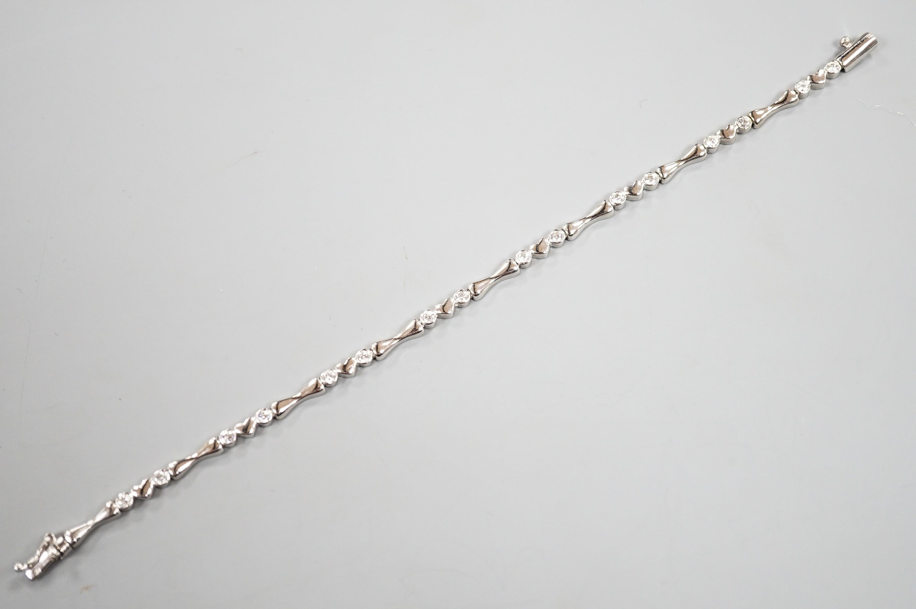 A modern 750 white metal and sixteen stone diamond set line bracelet, 19.2cm, gross weight 12.9 grams.